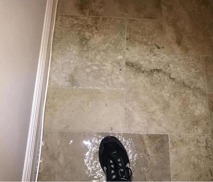 Water damage is shown on a tile floor